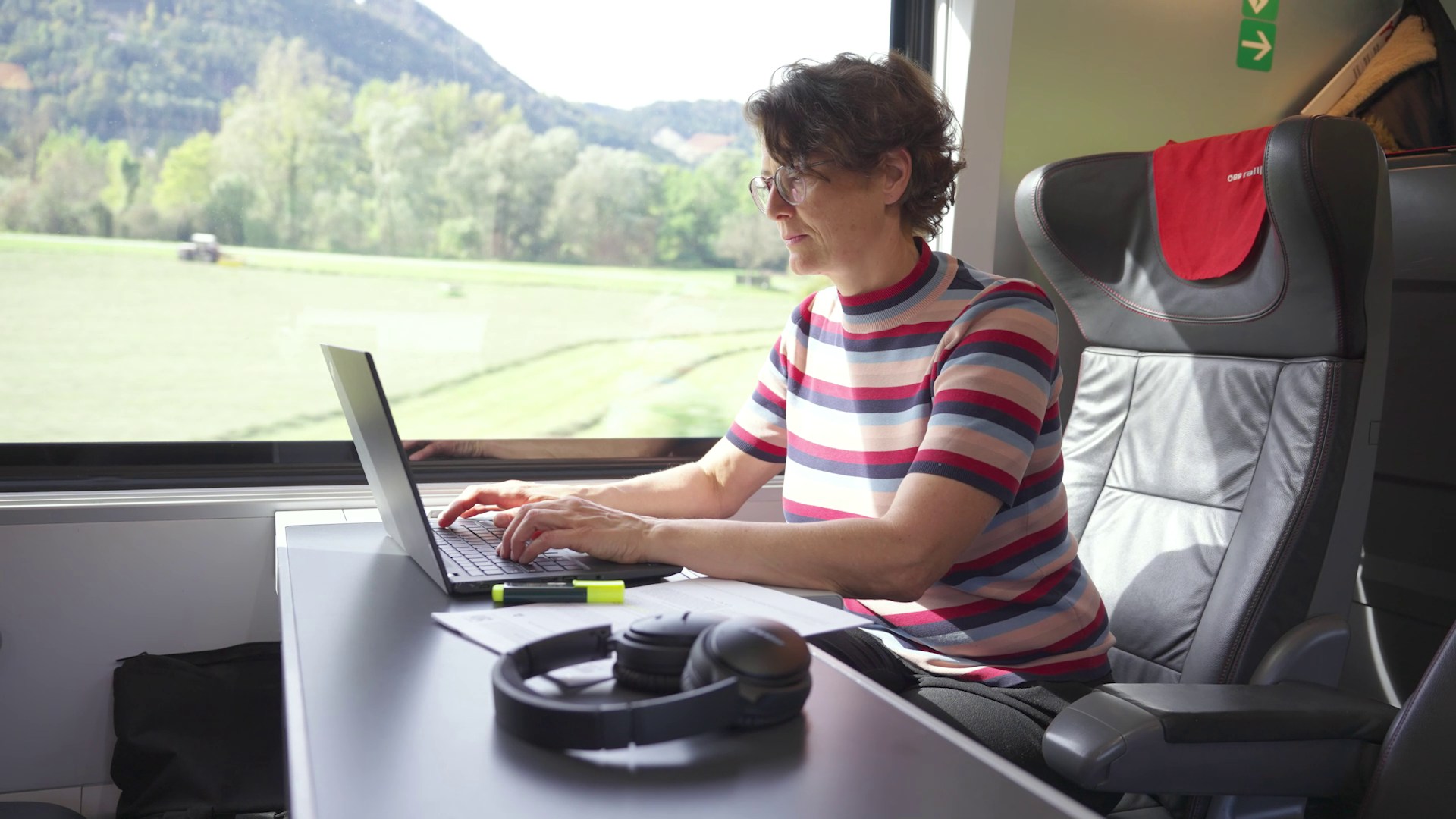 Eine Frau arbeitet im Zug an Ihrem Laptop